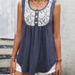 Women's navy sleeveless top with lace accents and buttons.