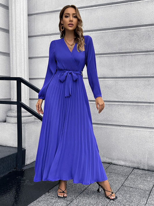 Flattering blue midi dress featuring a V-neckline and long sleeves.
