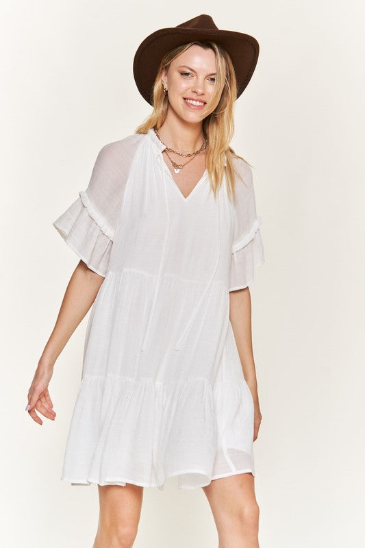 White tiered dress with ruffled sleeves and flowy fit.