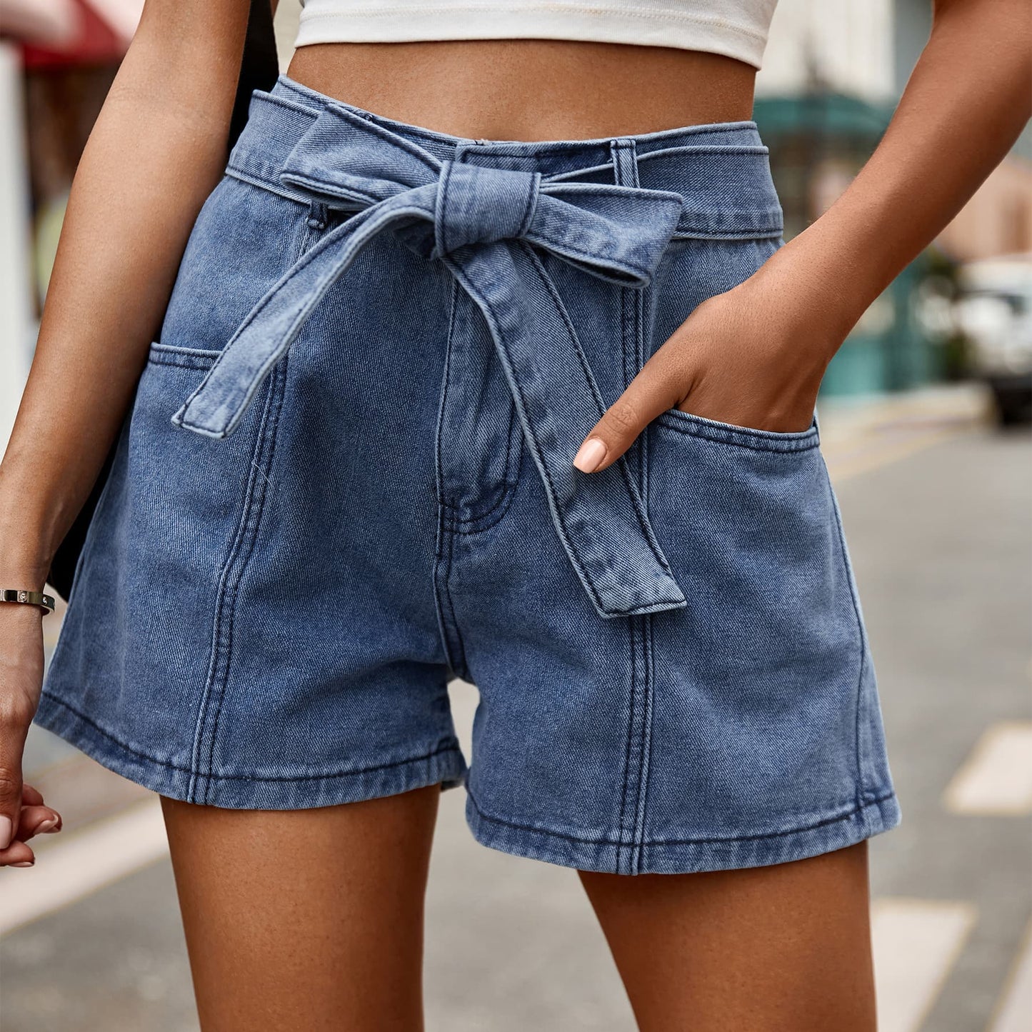 Chic high-waisted denim shorts with a trendy tie belt and convenient pockets, perfect for versatile summer styling
