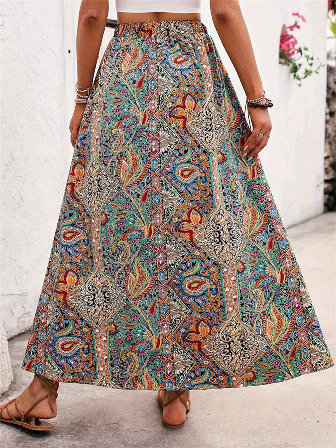 Flowy boho-chic maxi skirt featuring a colorful paisley pattern.