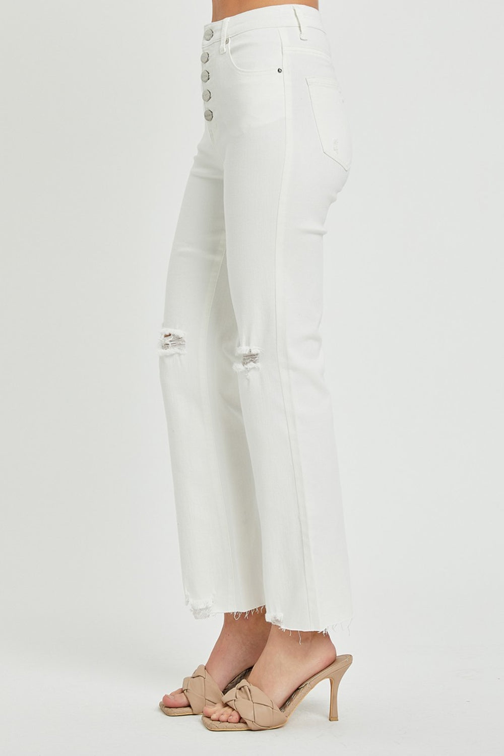 White high-waisted jeans with trendy distressed details and button fly.