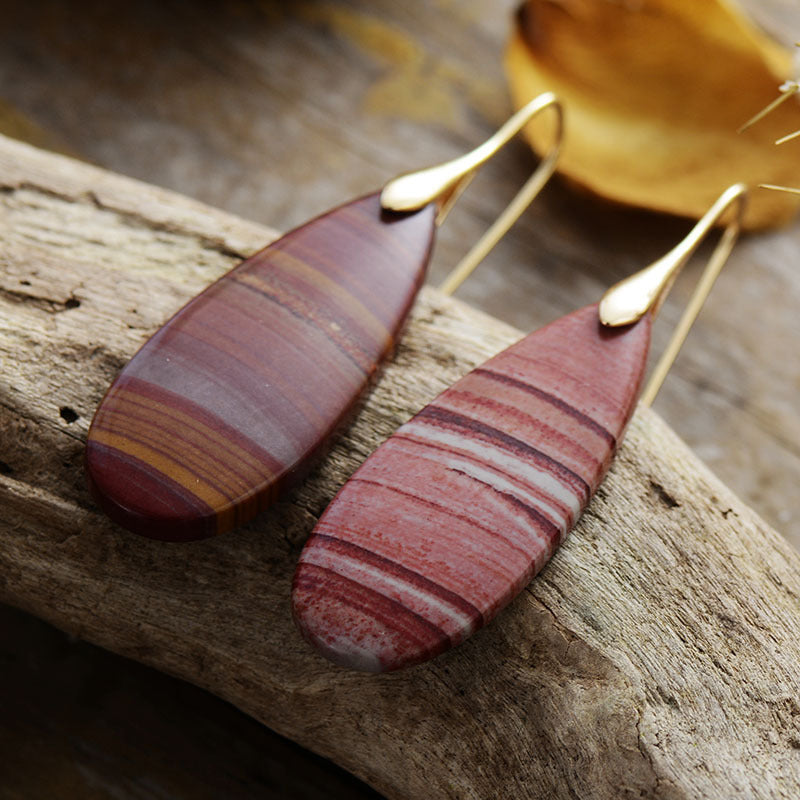 Brown teardrop earrings featuring a striped stone pattern and gold hooks.