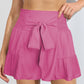 Chic hot pink high-rise shorts with a flattering smocked waistband and tie-front. Perfect for a stylish, comfy summer look.