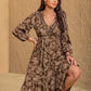 Woman posing in bohemian long sleeve V-neck printed midi dress.
