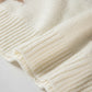 Close-up detail of the festive snowflake pattern on an ivory knit sweater, perfect for holiday events.