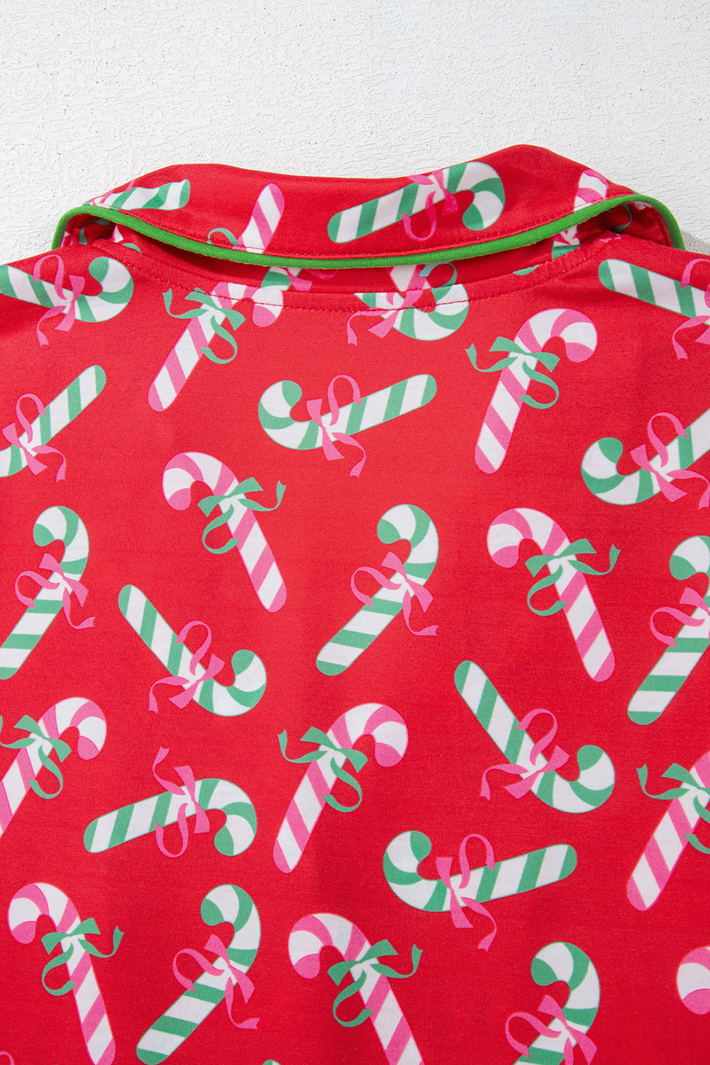 Festive pajama set featuring a candy cane pattern with green trim and a comfortable fit.
