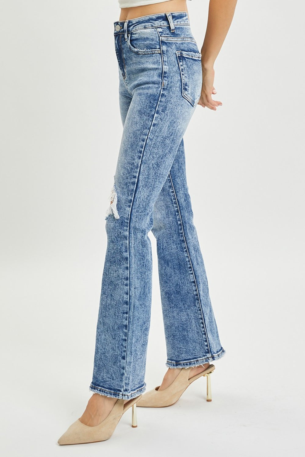 Flare jeans featuring a ripped knee and high-rise waist for a flattering fit
