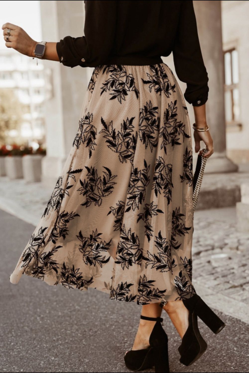 Semi-sheer khaki midi skirt featuring black embroidered floral design.
