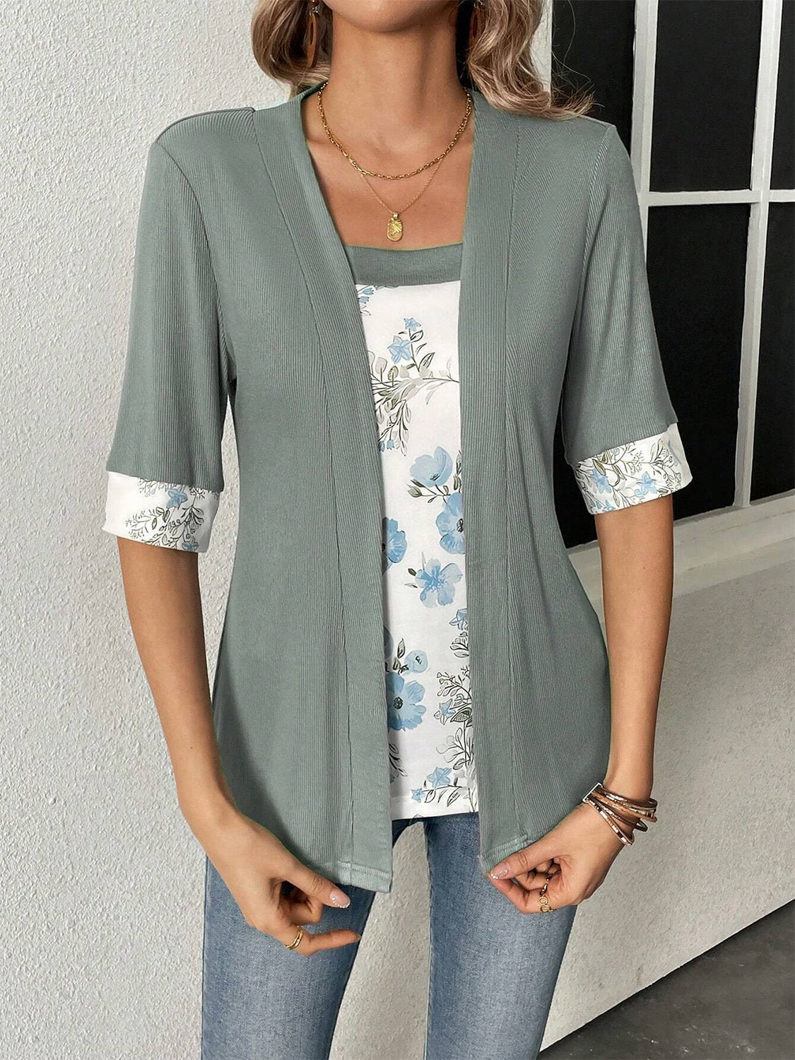 Woman styled in a gray and floral half-sleeve open-front top for spring