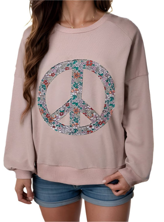 Woman wearing blush sweatshirt with floral peace sign
