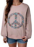 Woman wearing blush sweatshirt with floral peace sign
