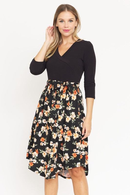 Black floral midi dress with wrap-style bodice and waist tie.
