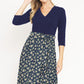 Stylish navy floral wrap midi dress with waist tie accent.
