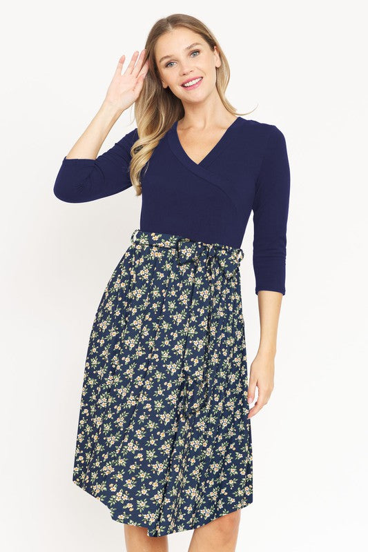 Stylish navy floral wrap midi dress with waist tie accent.
