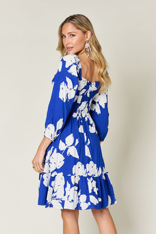 Women’s floral midi dress in royal blue with three-quarter-length sleeves.

