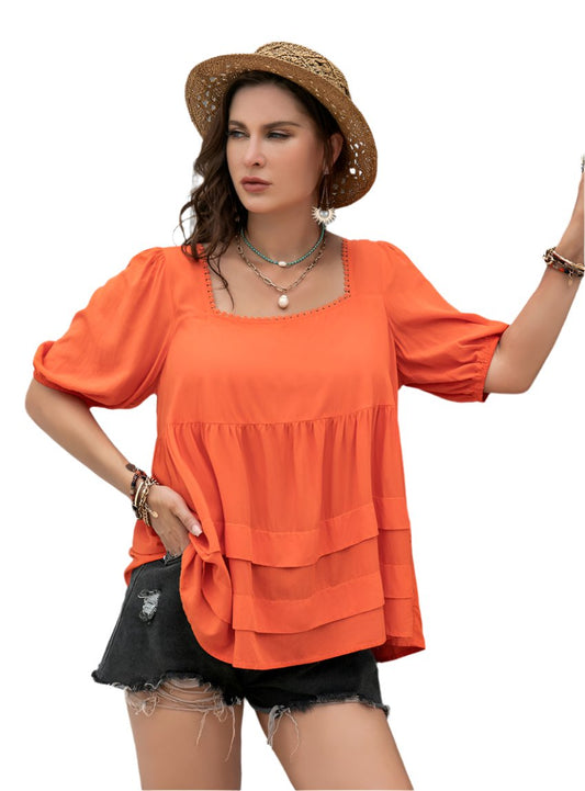 Vibrant orange peplum blouse with puff sleeves and tiered layers, perfect for warm weather