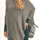 Soft gray fringed poncho styled for a cozy and fashionable fall or winter outfit.