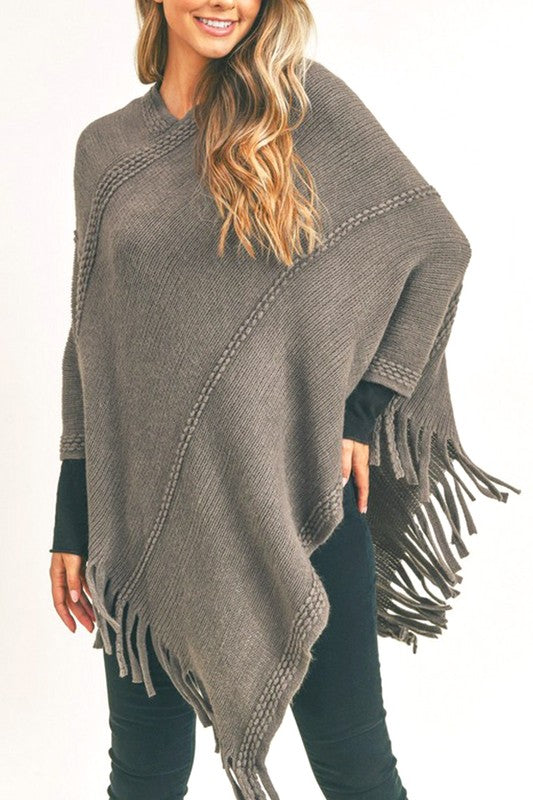 Soft gray fringed poncho styled for a cozy and fashionable fall or winter outfit.