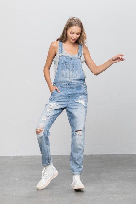 Close-up of light wash patch pocket ripped overalls for a trendy, relaxed style.
