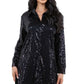 Close-up of a black sequin shirt dress showing the sparkling sequin detail and button-up front.
