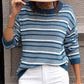 Full-length view of a blue and white striped sweater, paired with white jeans for a chic, casual outfit.

