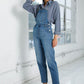 Full-length women’s overalls in medium wash blue denim.
