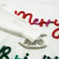 Fun holiday sweater featuring "Merry & Bright" in colorful tinsel lettering, perfect for casual winter outfits and Christmas events.