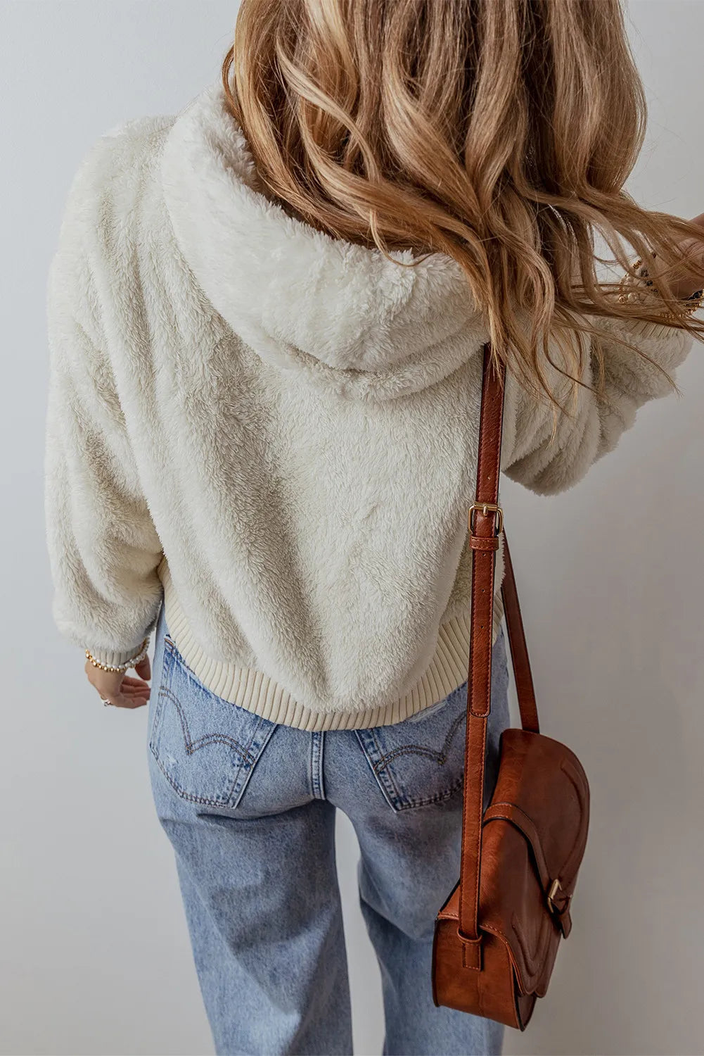 Women's fuzzy beige hoodie with dropped shoulder sleeves, casual style.
