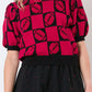 Detailed view of the checkerboard football pattern on a red and black puff sleeve sweater.