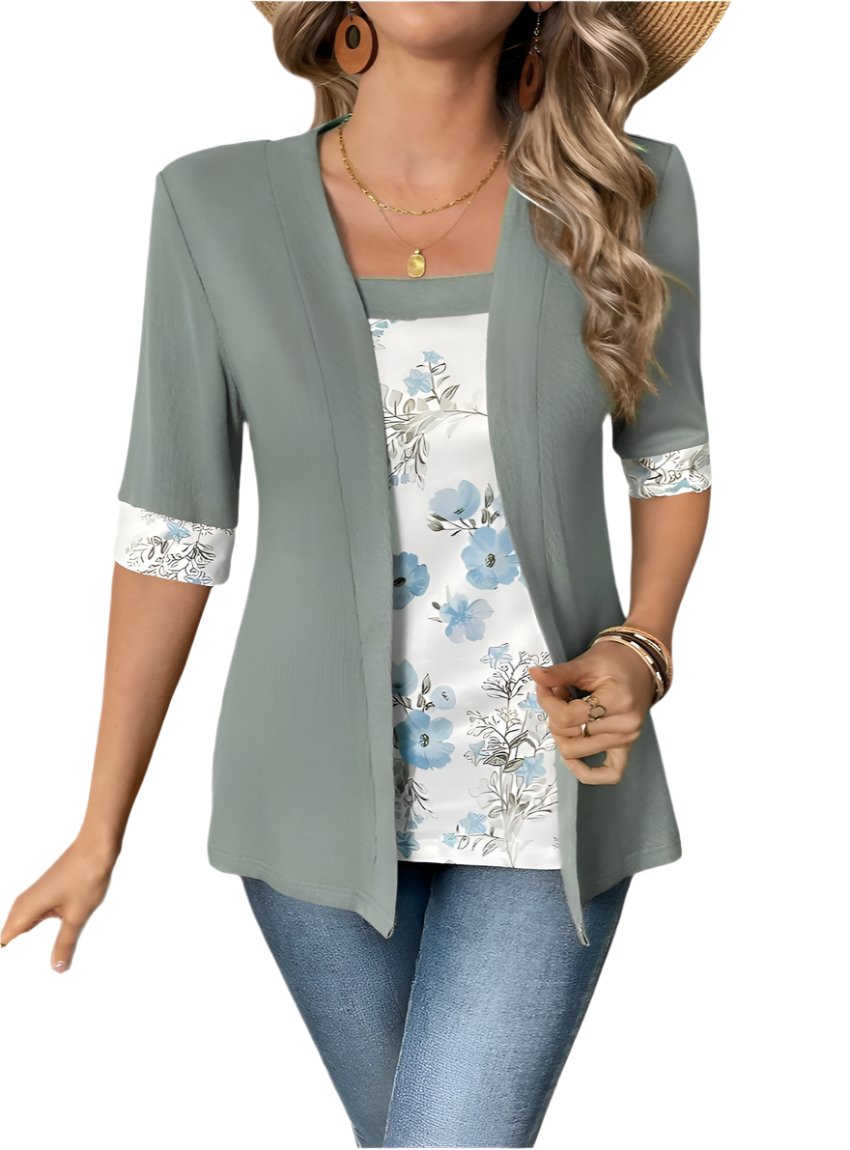 Woman wearing a gray half-sleeve top with floral accents and blue jeans