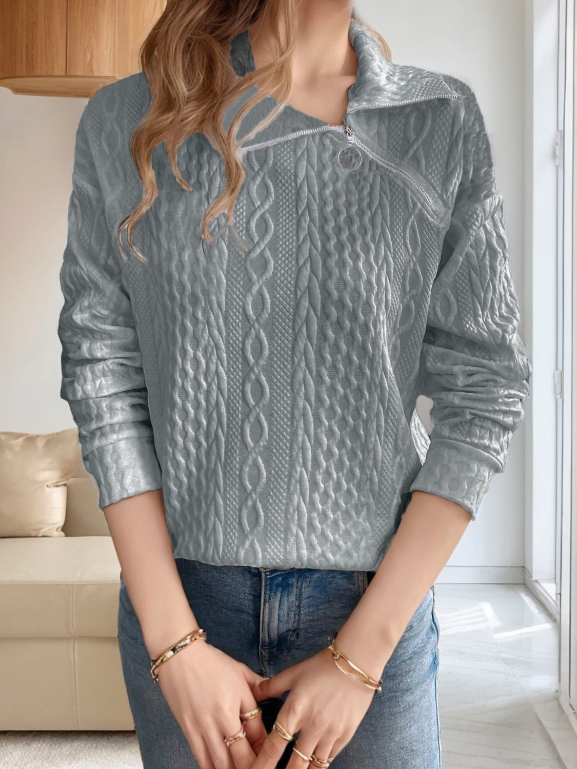 Cozy gray knit quarter-zip sweater styled for layering with a casual winter outfit.

