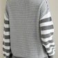 Gray striped sweater with dropped shoulders, perfect for layering in winter.
