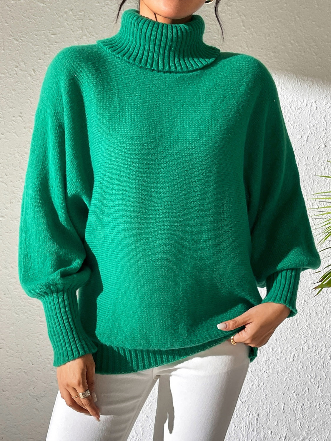 Woman in green oversized turtleneck sweater with slouchy fit