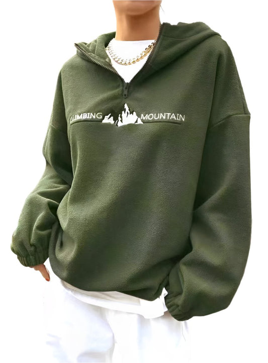 Woman wearing a green "Climbing Mountain" fleece pullover.
