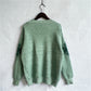 Back view of the green reindeer knit sweater, highlighting the relaxed fit and holiday-themed design.

