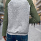 Green quilted pullover styled for casual wear with jeans