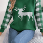 Close-up of green knit sweater with a white reindeer design and plaid sleeves, perfect for holiday gatherings.