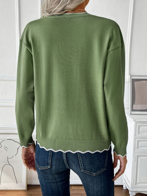 Soft knit green sweater with scalloped trim, styled for casual wear.
