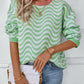 Front close-up of the green wavy striped knit sweater, great for casual outings or lounging.

