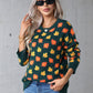 Green fall sweater with orange leaf print, perfect for autumn outfits.

