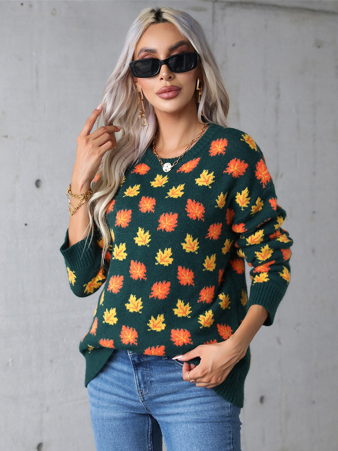 Green fall sweater with orange leaf print, perfect for autumn outfits.

