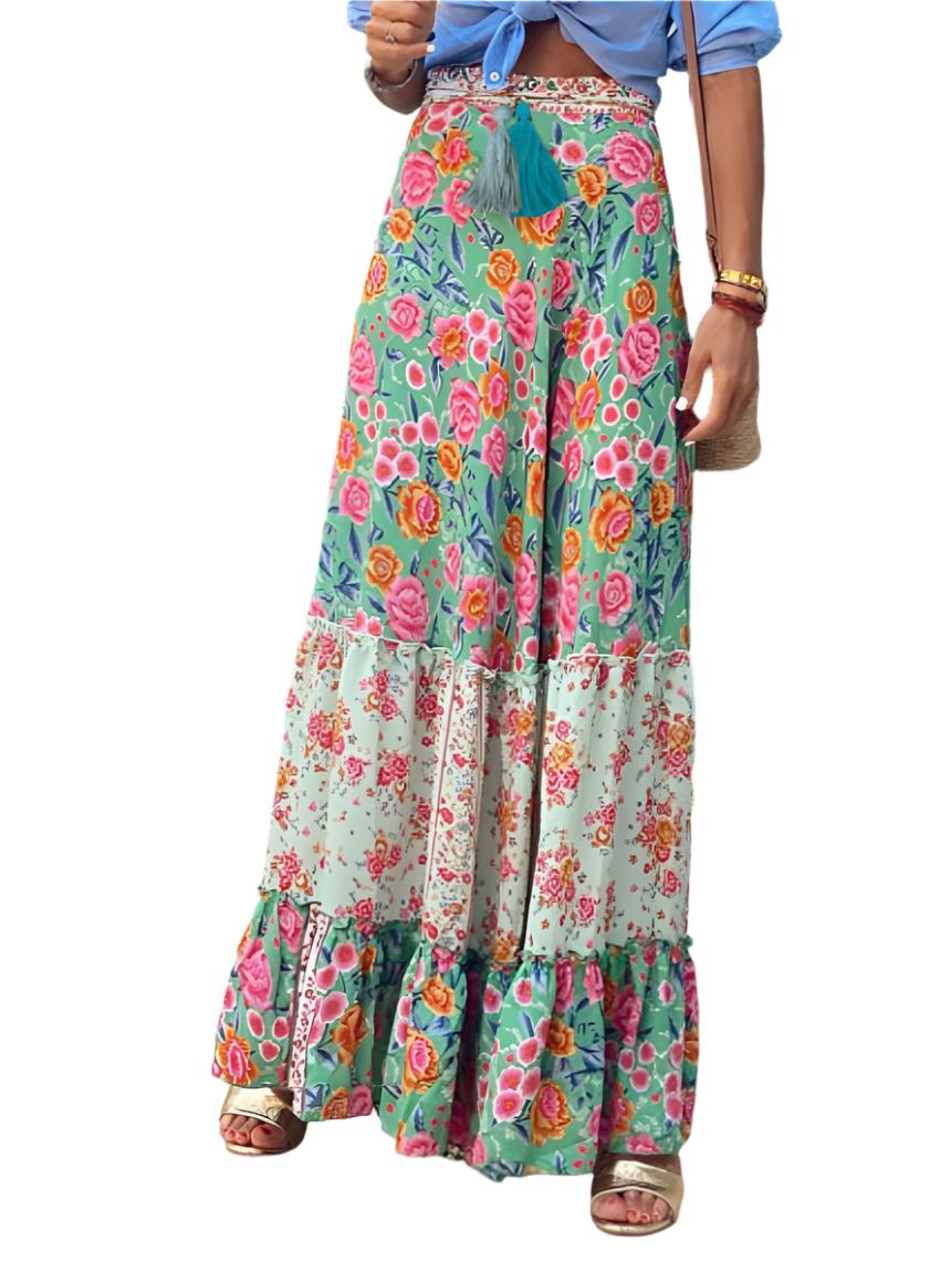 Front shot of a green tropical print ruffled maxi skirt with tiered layers.
