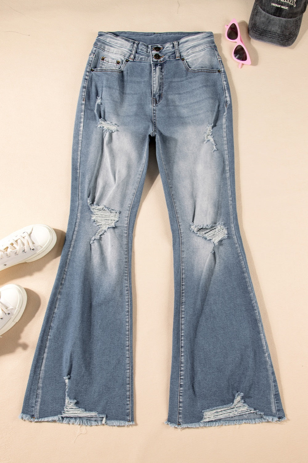 Trendy women's bootcut jeans with a raw hem and distressed look.