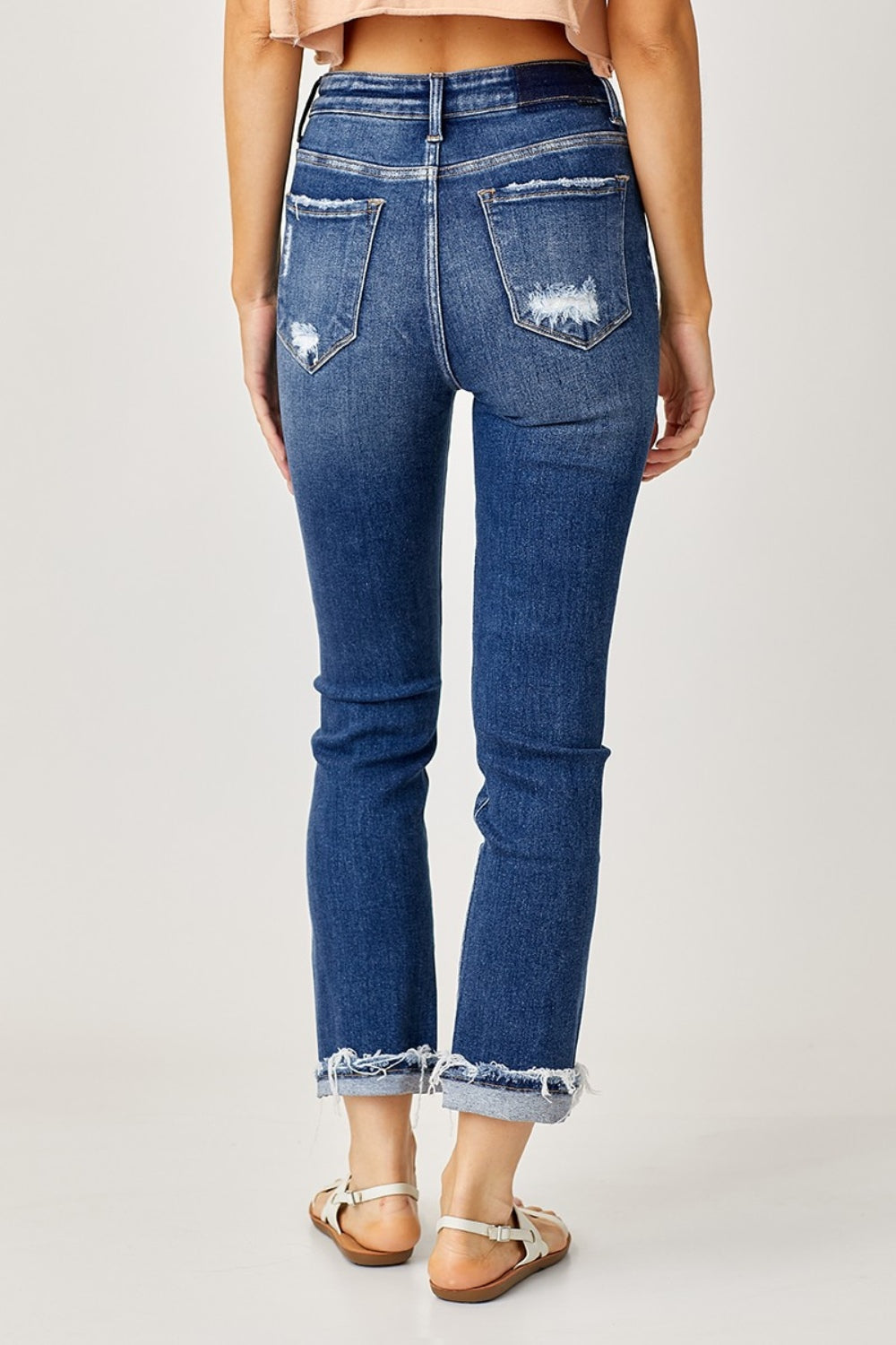 Medium-wash cuffed straight jeans with frayed hems for a laid-back look
