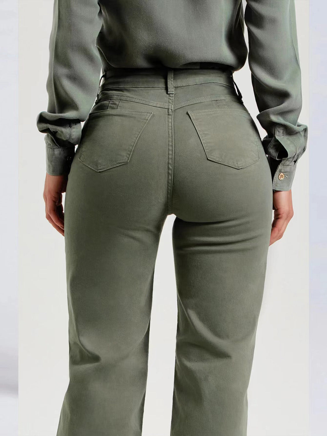 High-rise waist of green straight leg raw hem jeans.