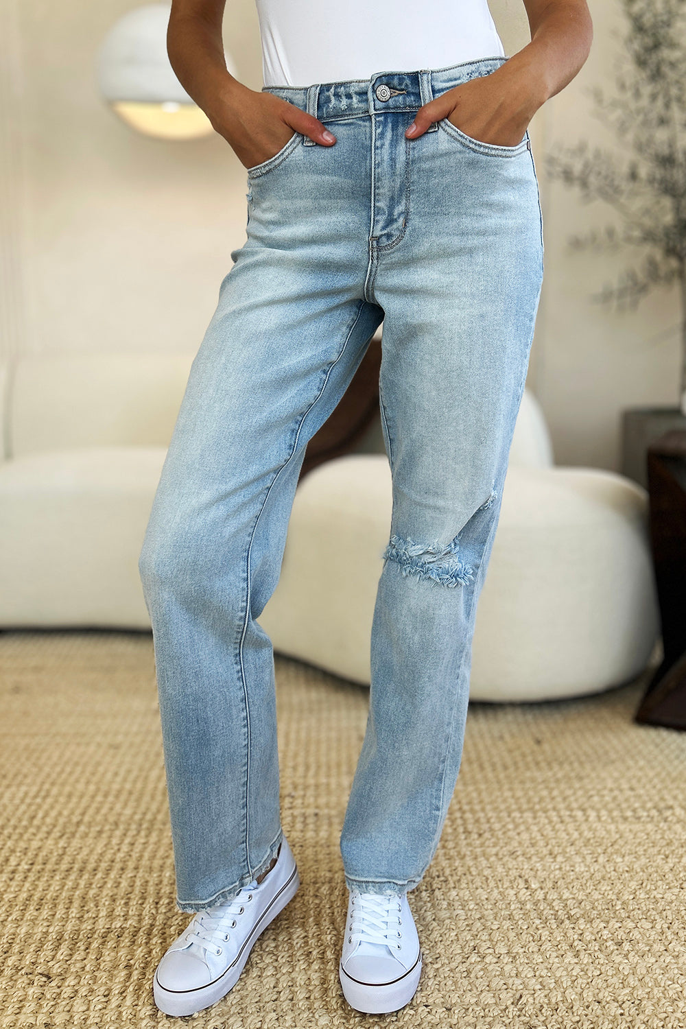 High-waisted distressed jeans with frayed hem by Judy Blue.