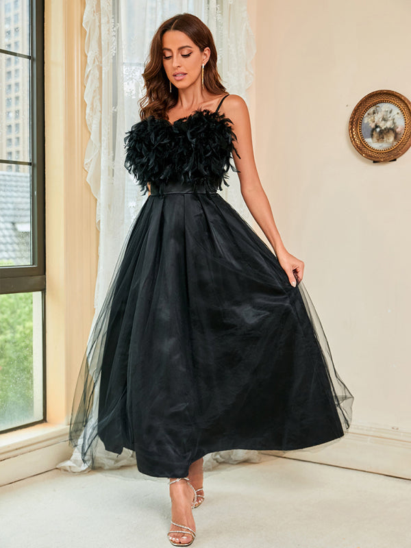 High-waisted black dress with mesh overlay and feather details for a bold look.
