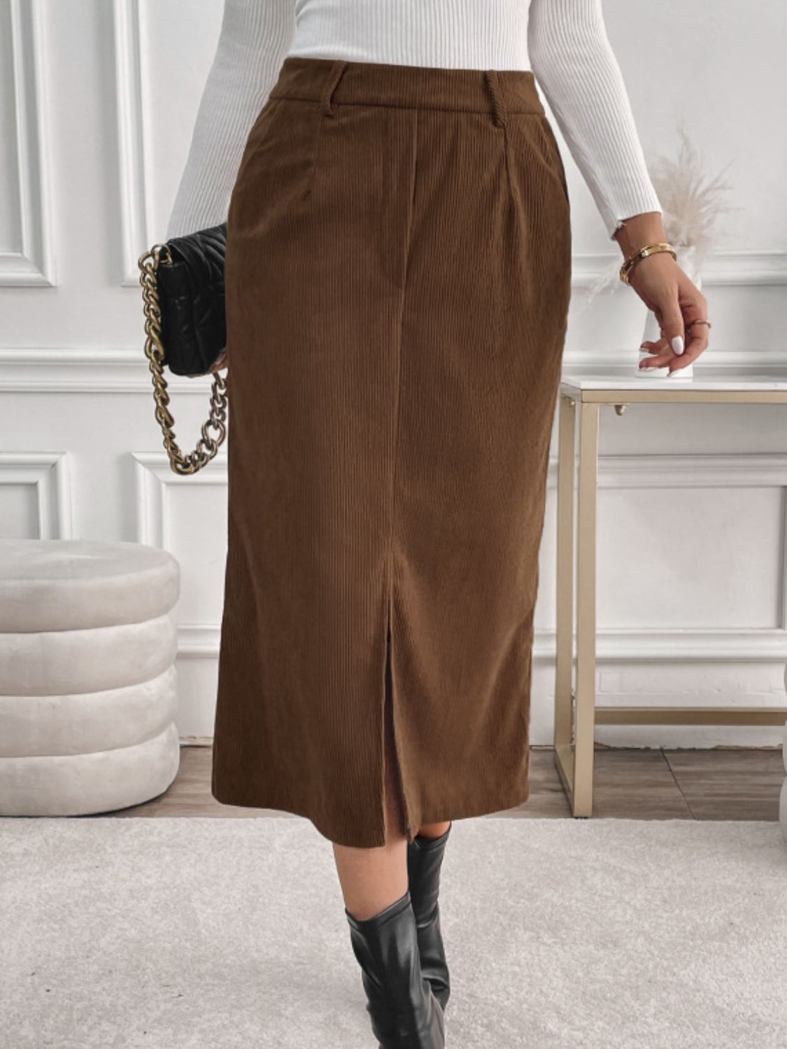 Women's brown corduroy midi skirt, featuring pockets and a front slit.
