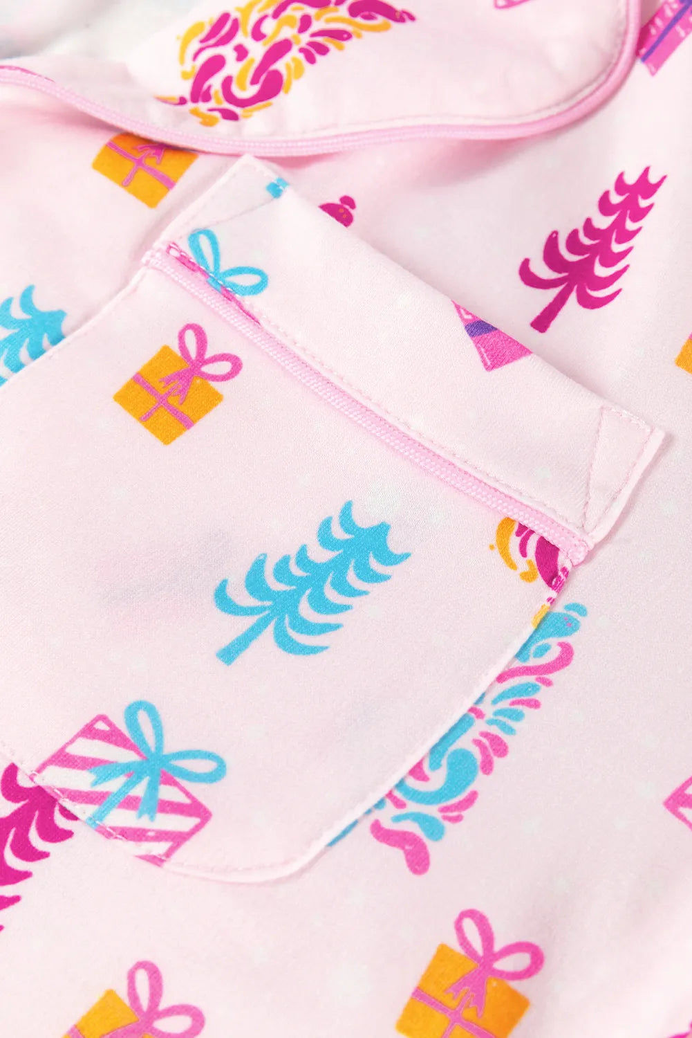 Close-up of pink holiday-themed sleep shirt with festive print.
